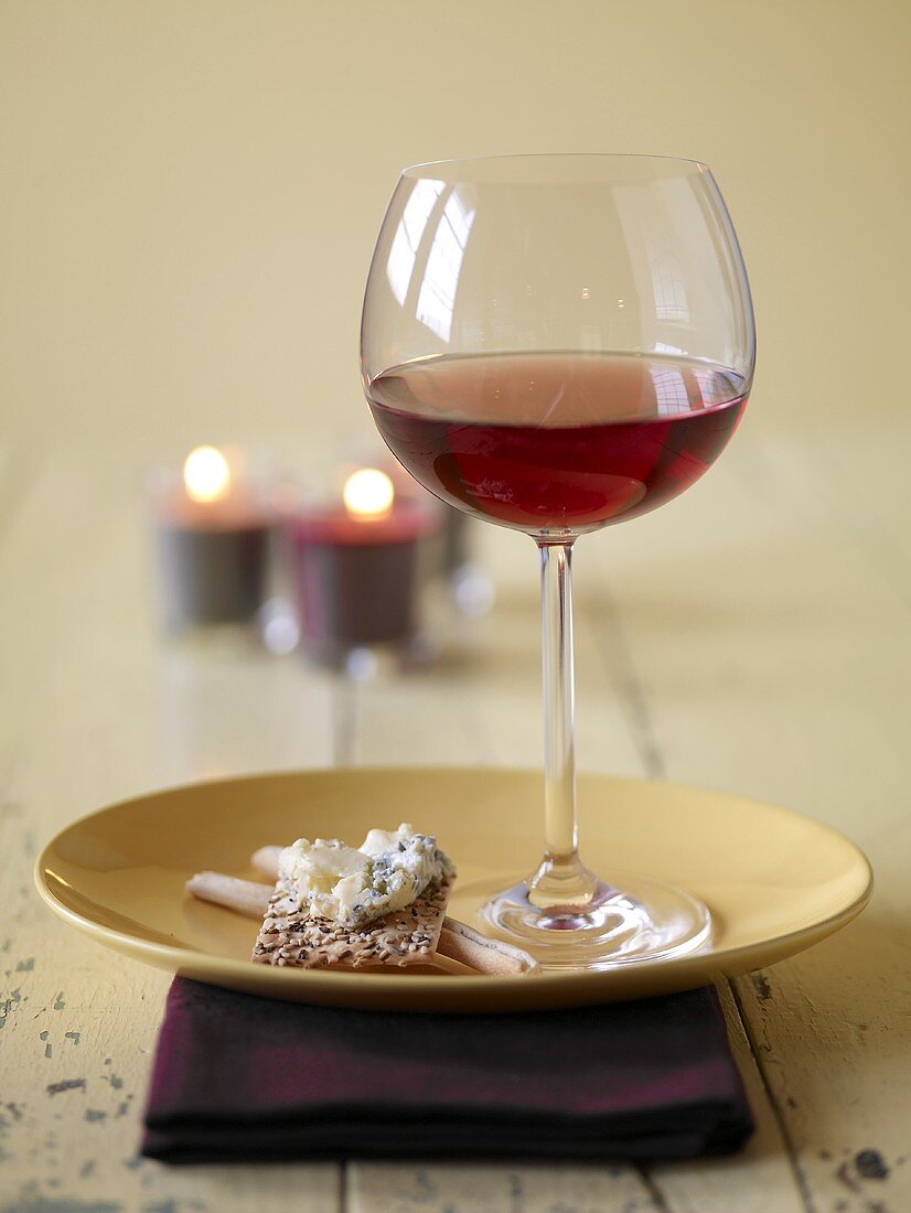 Ein Glas Rotwein und Cracker mit Blauschimmelkäse