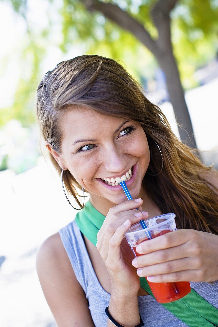 A teenager in a park with a drink