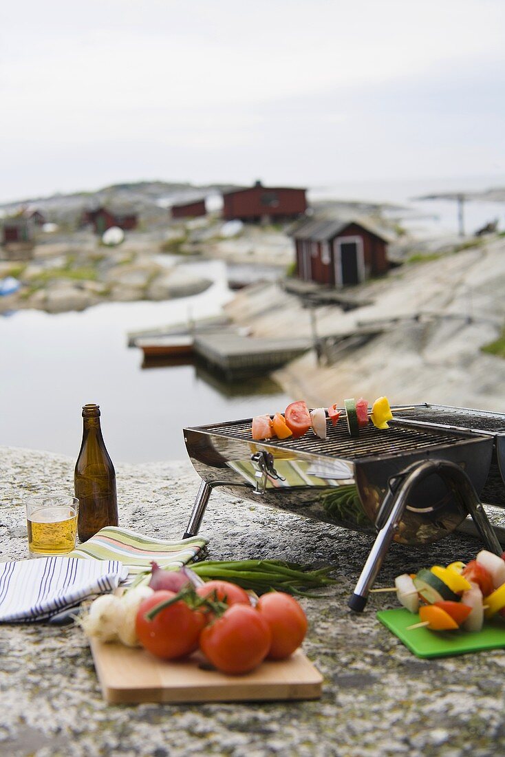 Kebabs on a barbeque on a rocky beach in Scandinavia