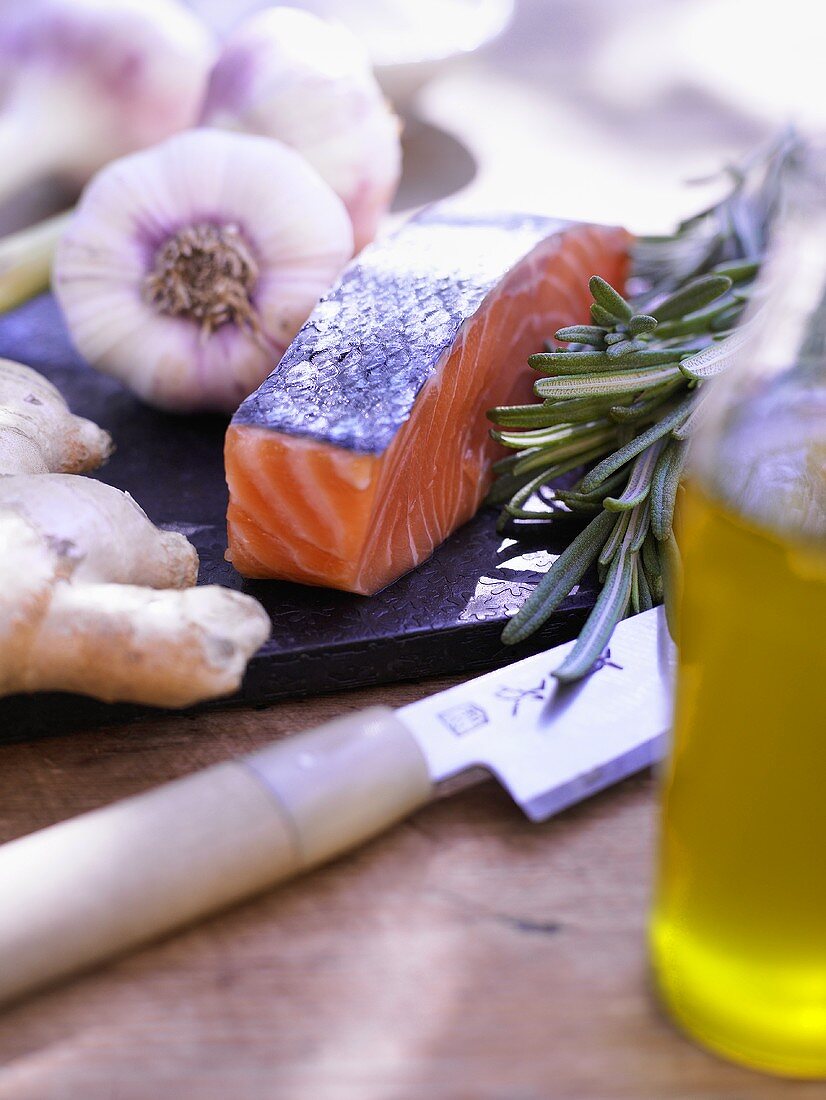 An arrangement of salmon, garlic, ginger, rosemary and olive oil