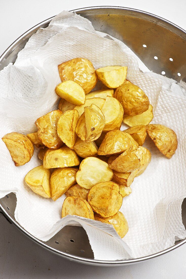 Fettgebackene Kartoffeln beim entfetten auf Küchenkrepp