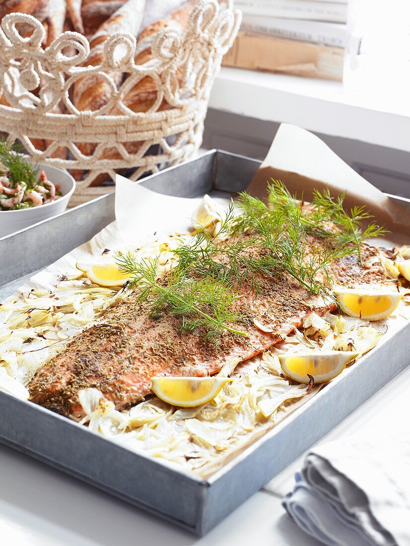 Fish with dill and lemons on a baking tray