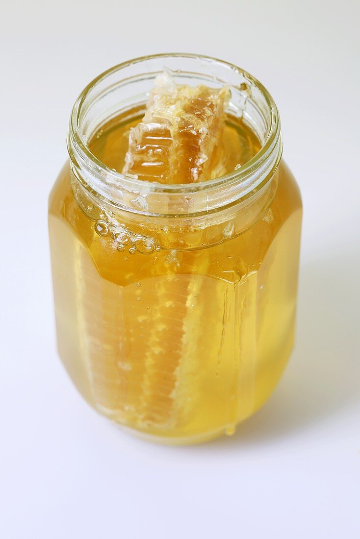 A honey comb in a jar of honey