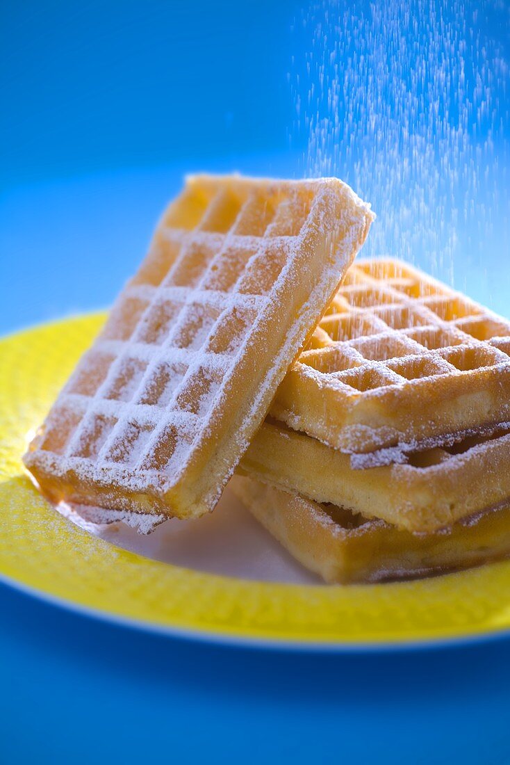 Sprinkling waffles with icing sugar