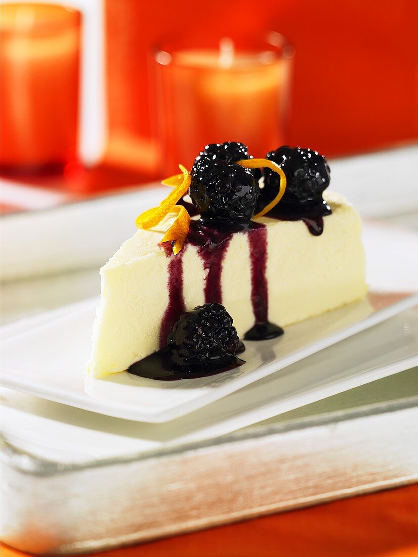 A piece of cheese cake with blackberry sauce