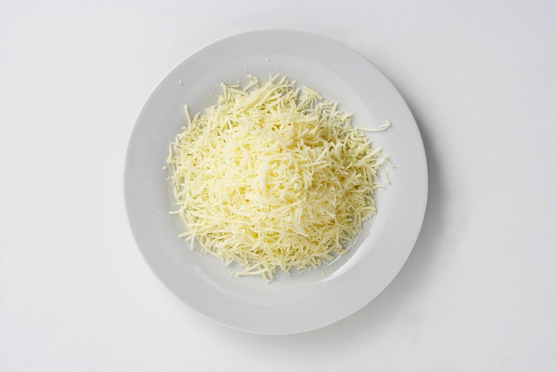 Geriebener Käse auf Teller von oben