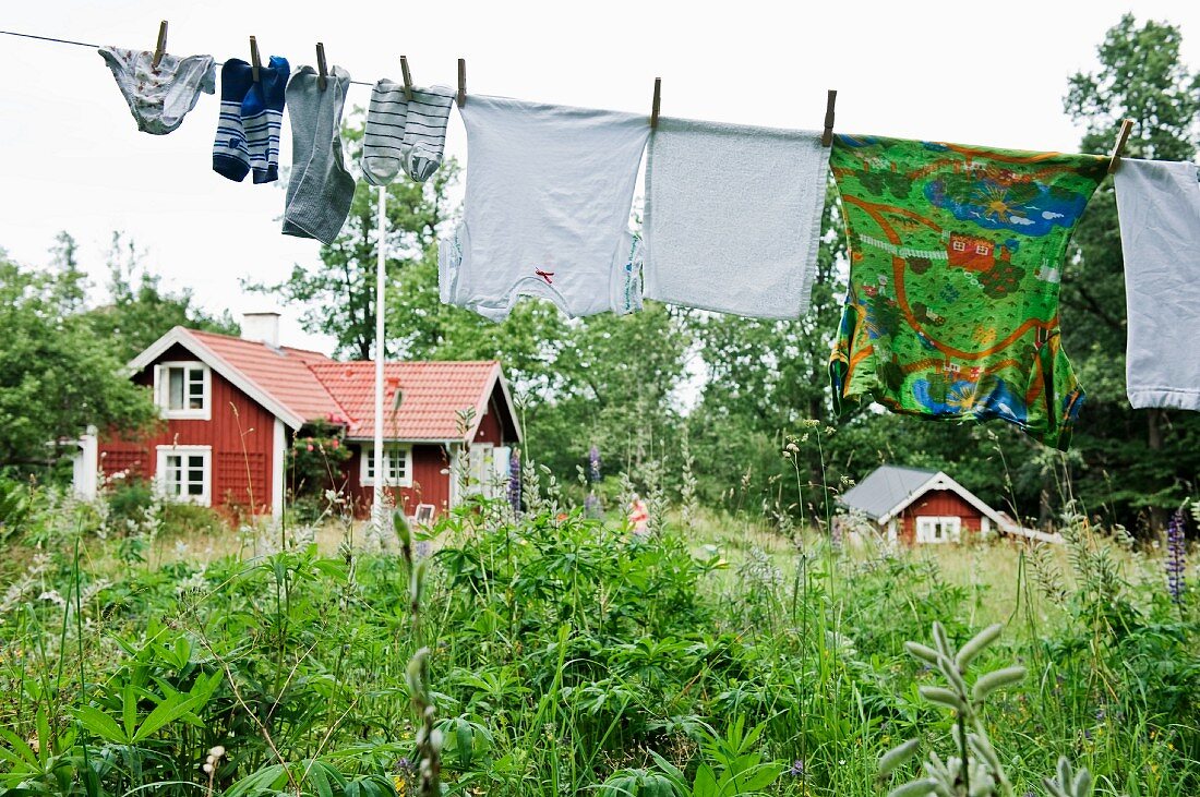 Wäscheleine im Garten vor Holzhäusern (Skandinavien)