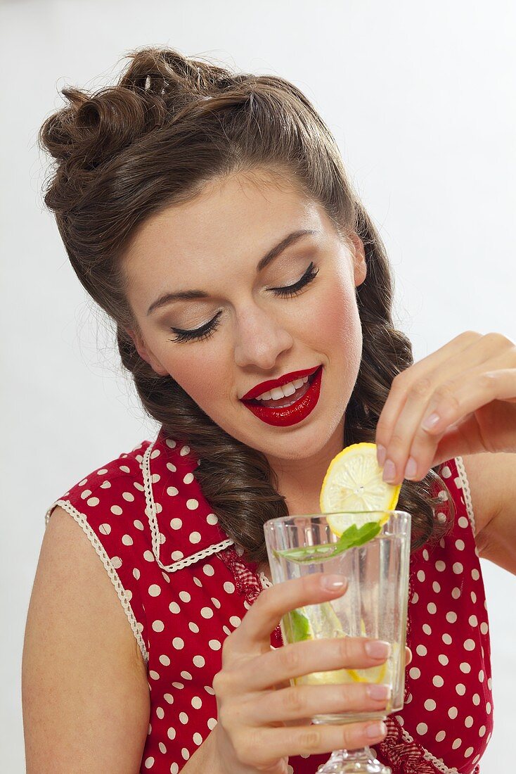 Mädchen im Retro-Look trinkt Zitronenlimonade