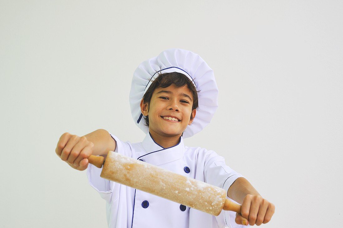 Junge als Koch mit Nudelholz