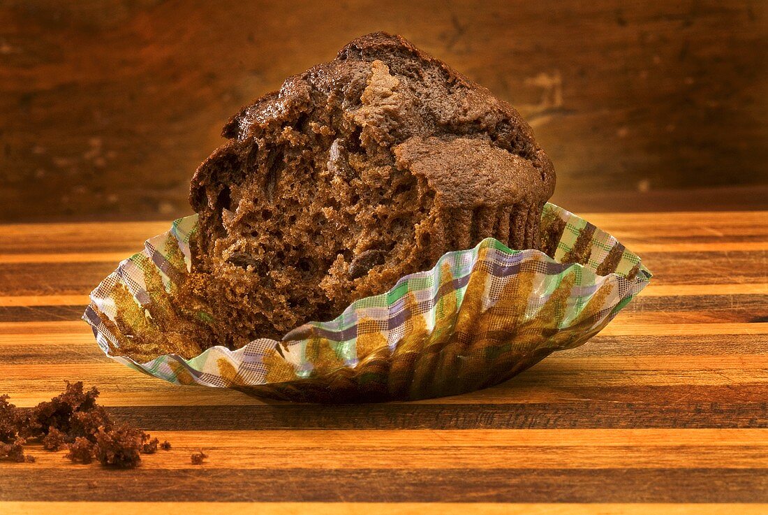 Chocolatechip Muffin im Papierförmchen, angebissen