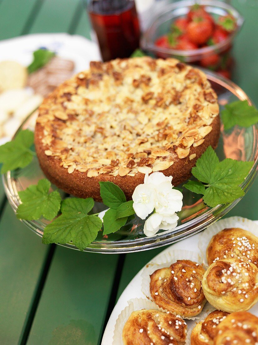 Almond cake and cinnamon buns on a garden table
