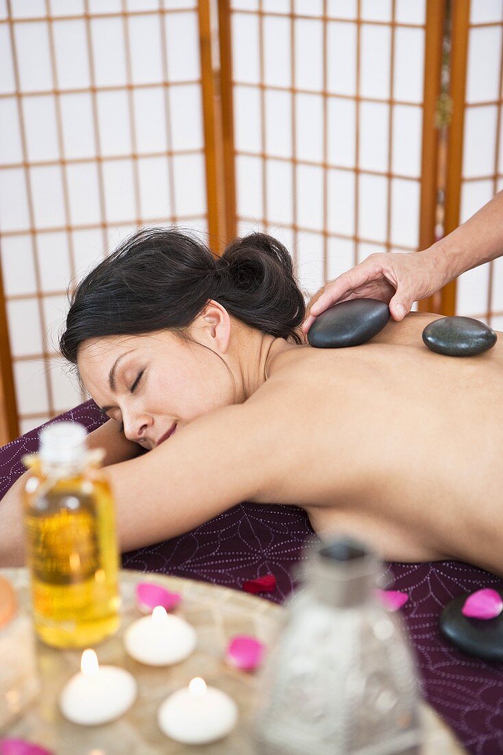 A woman having a La Stone massage in a spa