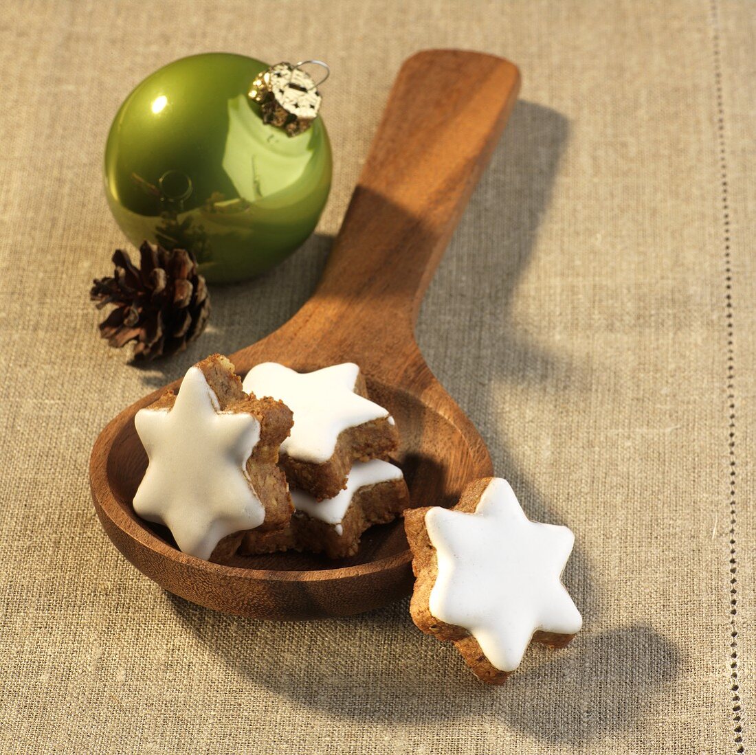 Cinnamon stars on a wooden spoon and Christmas decorations