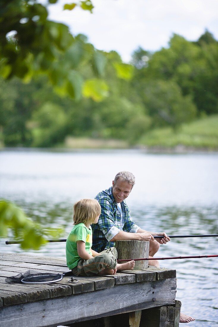 A father and son fishing by a lake