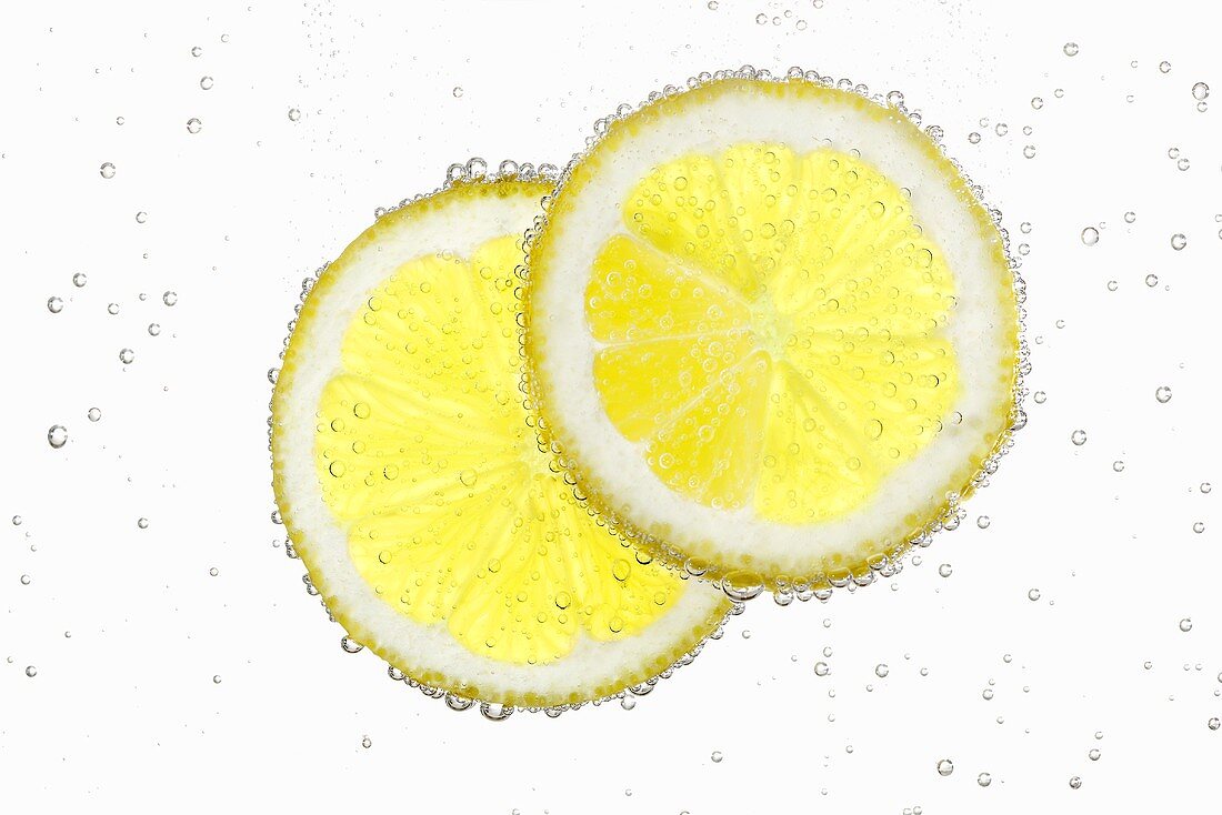 Zwei Zitronenscheiben im Wasser mit Luftbläschen