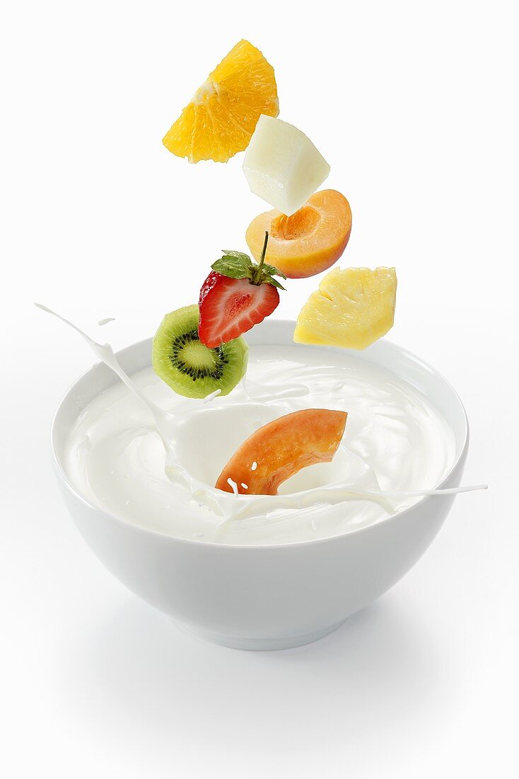 Fresh fruit falling into a bowl of yogurt