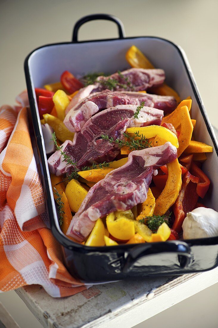 Raw lamp chops with a pumpkin medley in a roasting tin
