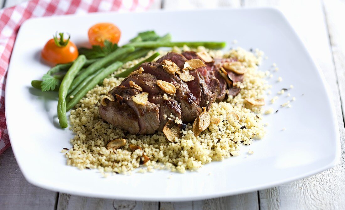 Beef with garlic on a bed of couscous