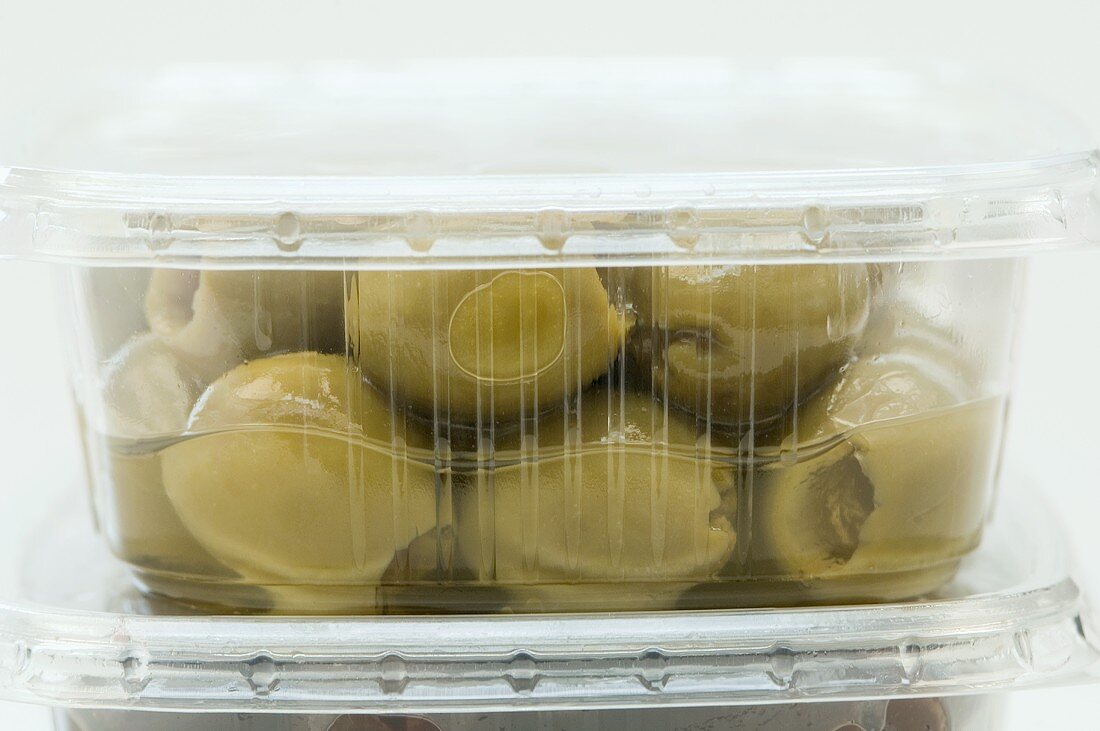 Green olives in a plastic container (close-up)