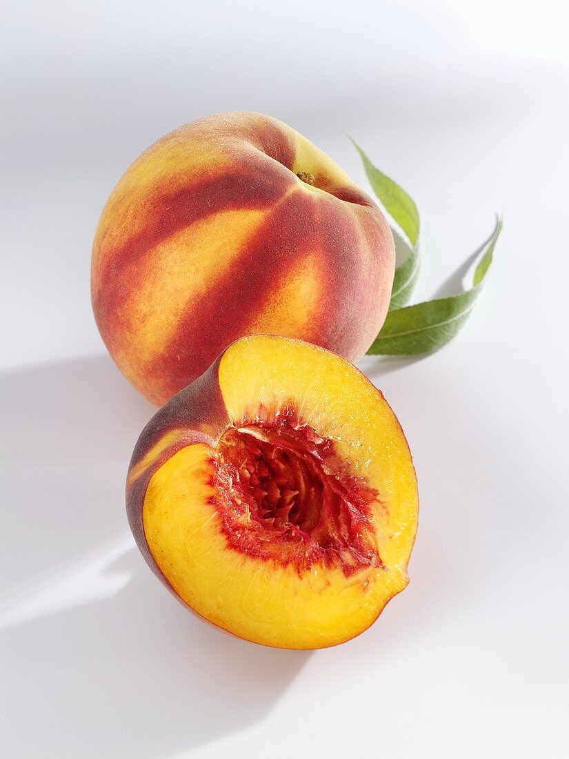 A whole and a halved peach