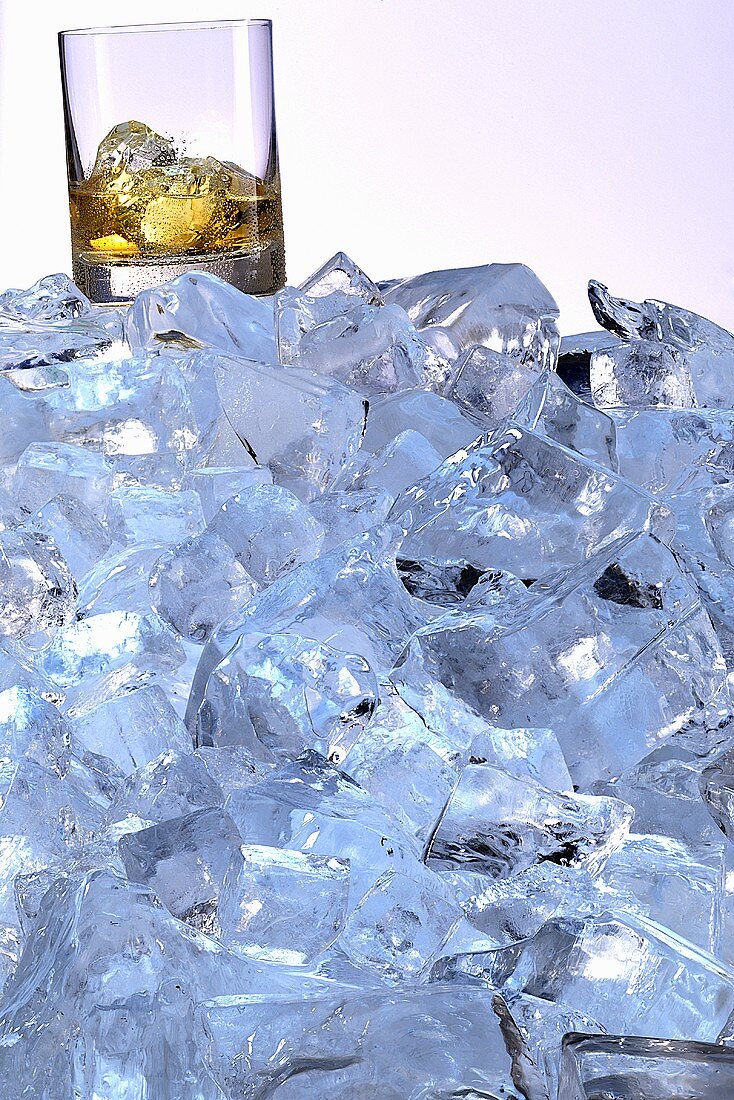 A whiskey glass on a mountain of ice cubes