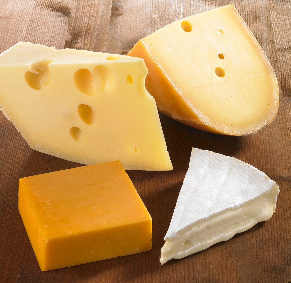 Four pieces of cheese (Emmentaler, Gouda, Cheddar and Brie)