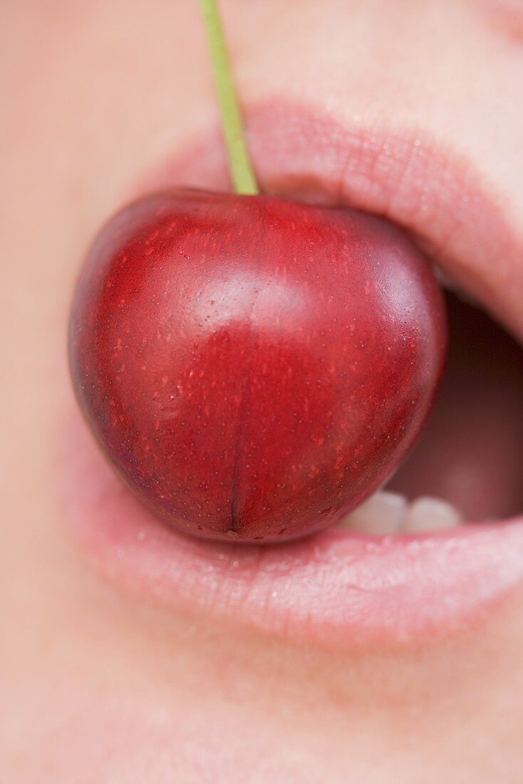 A cherry in a mouth (close-up)