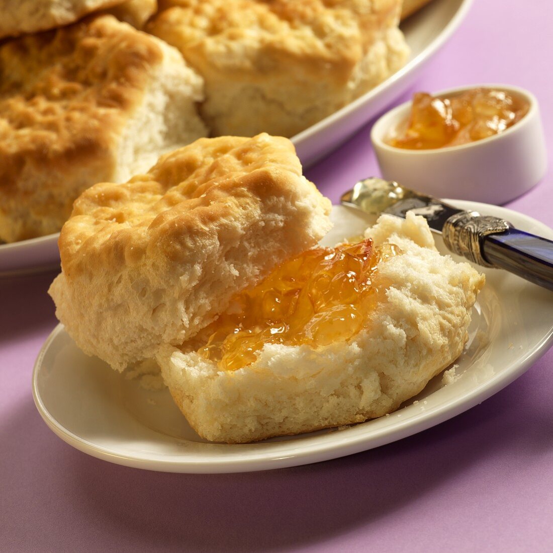 Biscuit with Orange Marmalade on a Plate; Knife; Plate of Biscuits