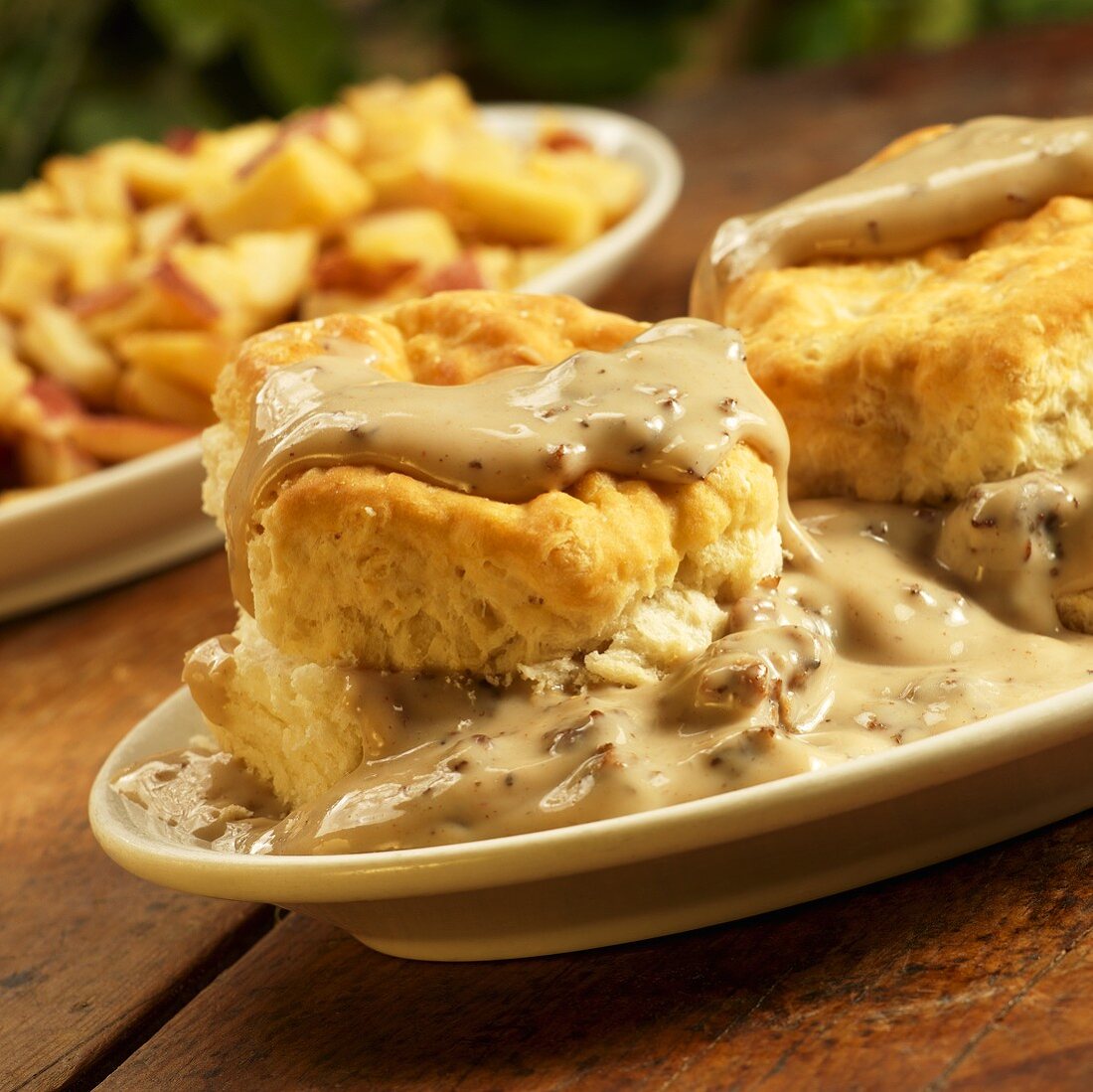 Biscuits with Sausage Gravy; On Rustic Table; Home Fries