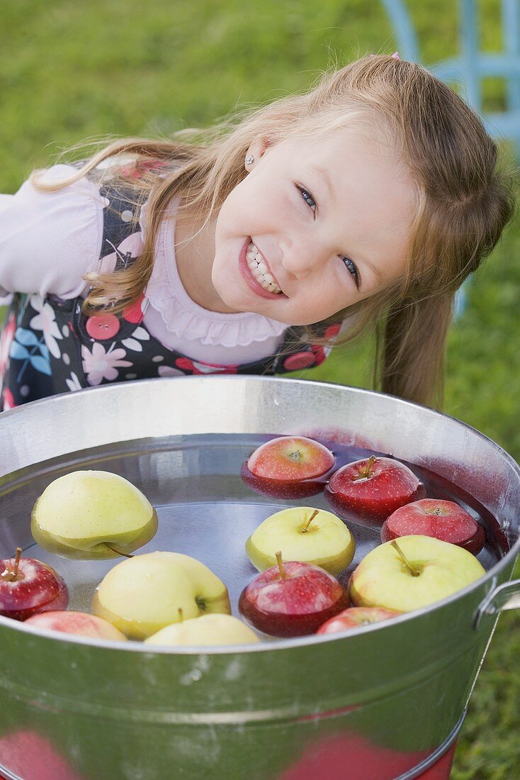 A girl bobbing for apples