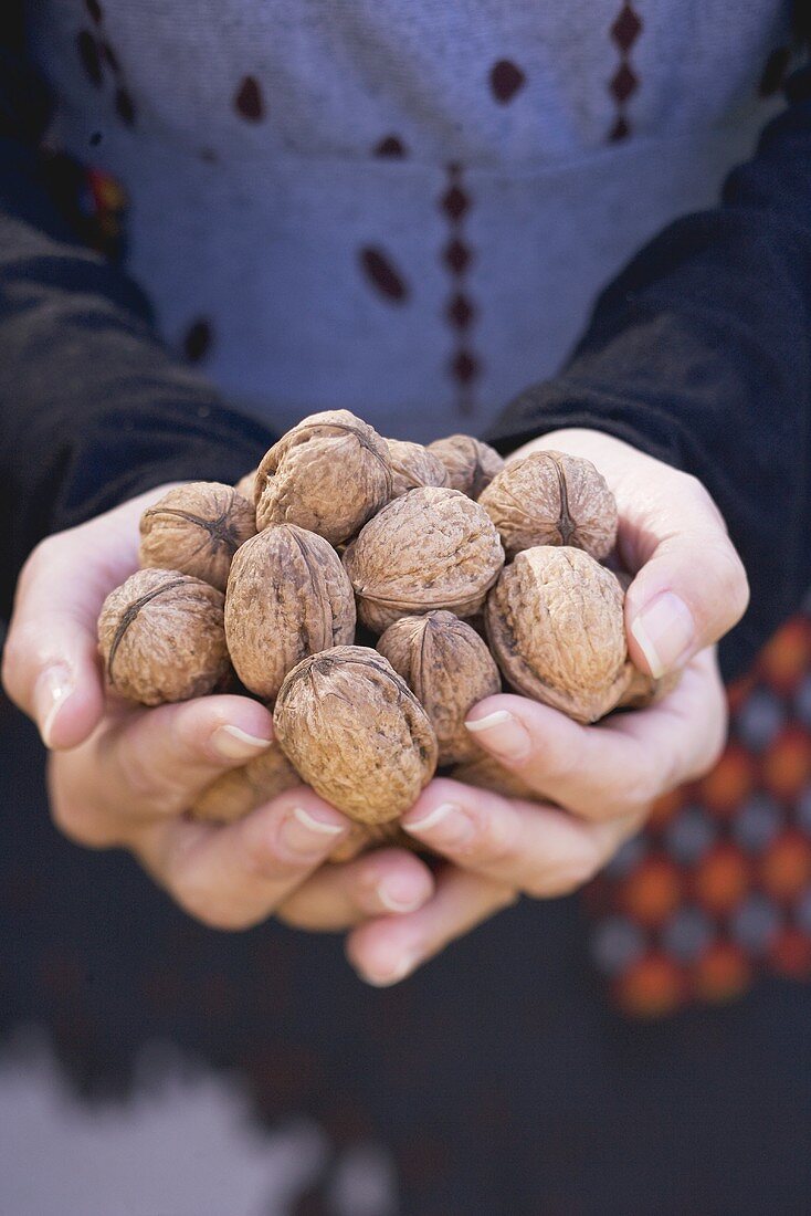 A woman holding walnuts