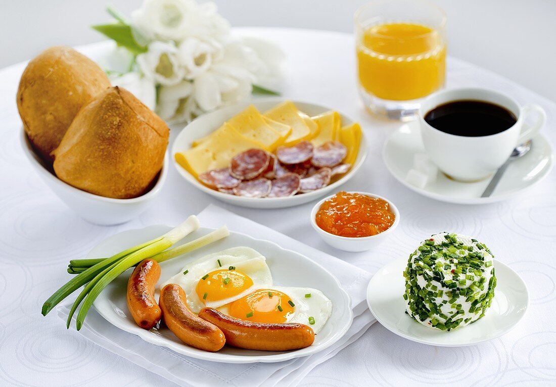 Frühstück mit Würstchen, Spiegelei, Wurst-Käse-Platte, Kaffee, Marmelade