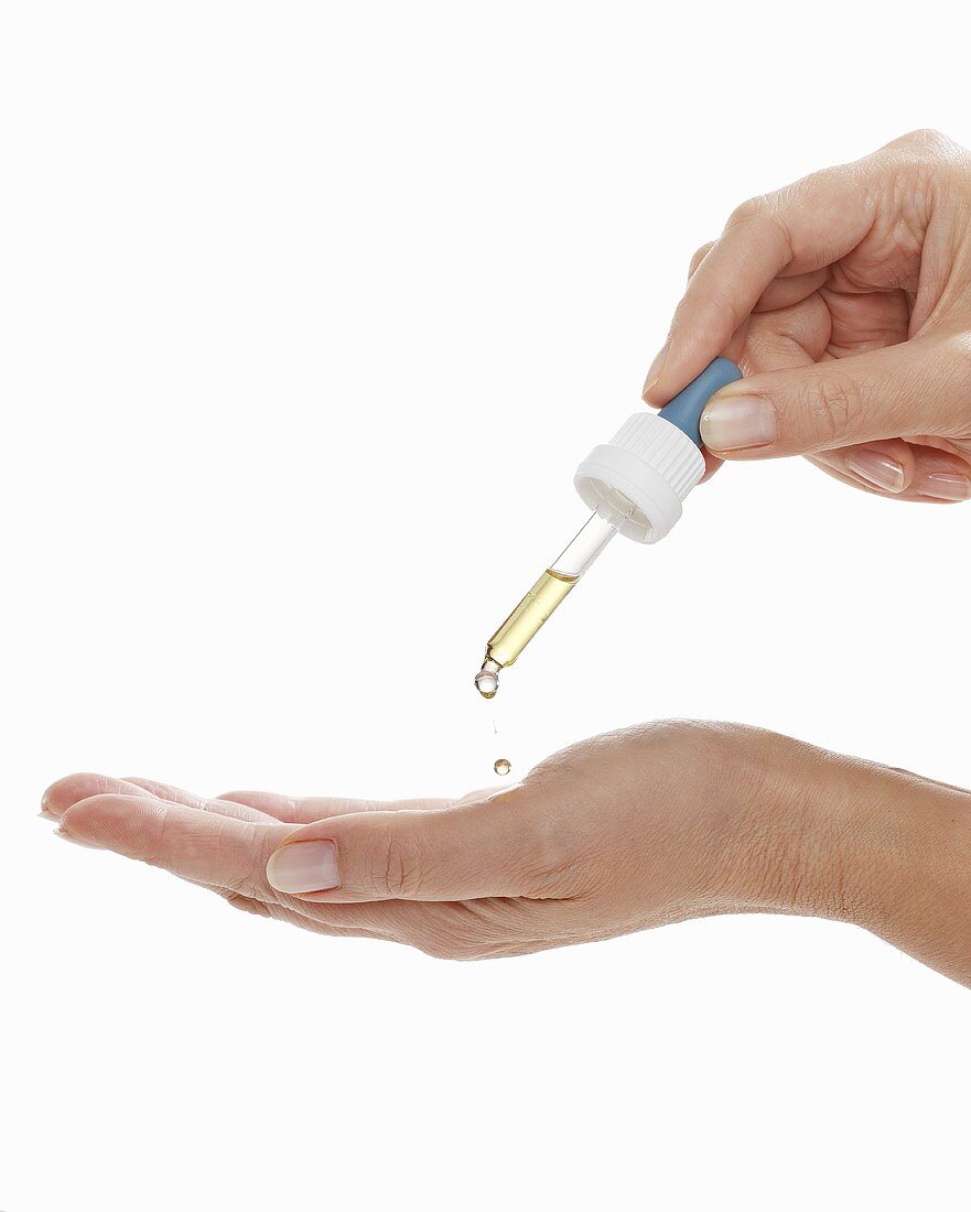 Liquid being dripped onto the palm of the hand with a pipette