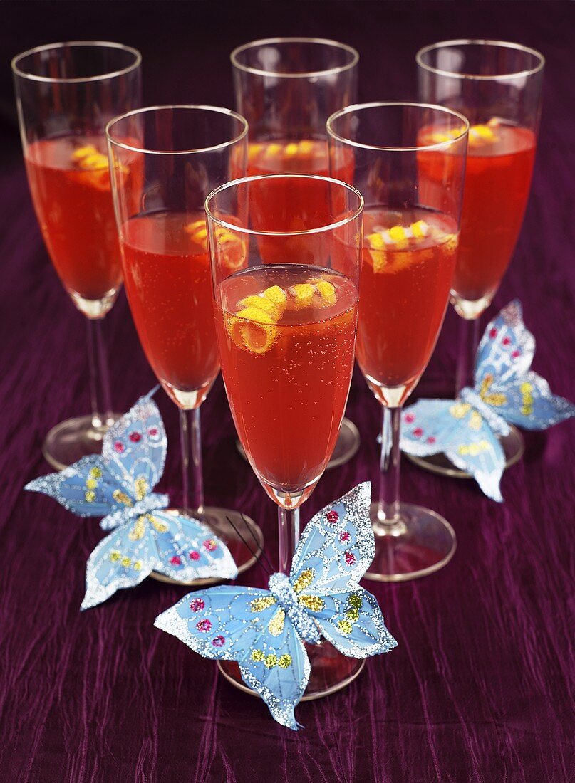 Red cocktail with champagne with butterfly decoration