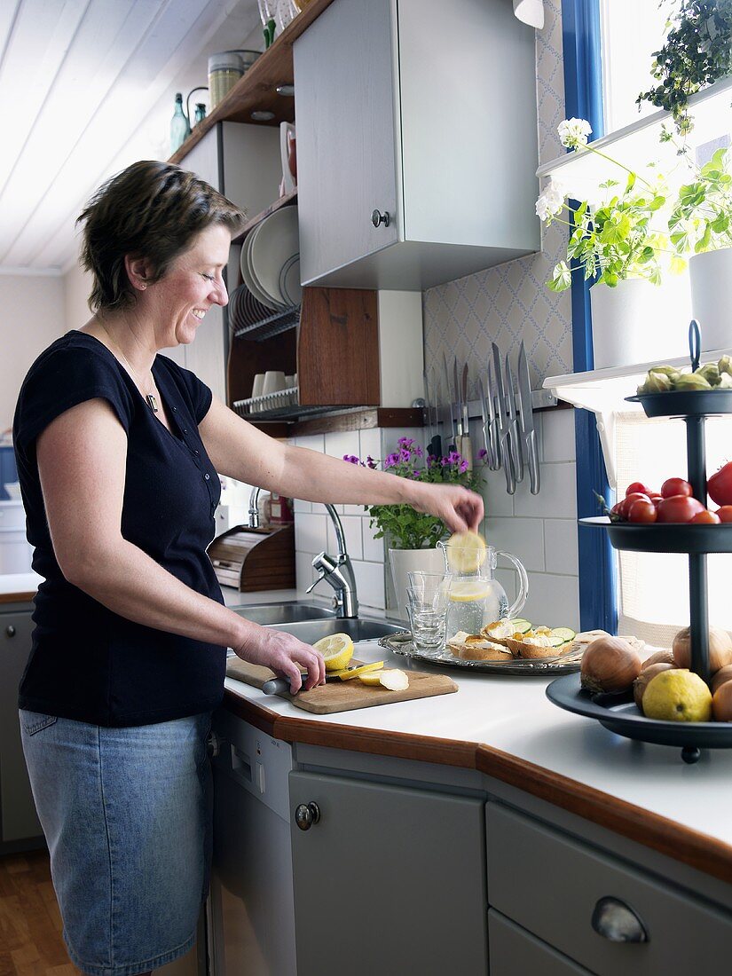 Frau beim Zubereiten von Limonade in einer Küche