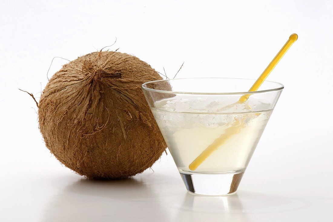 Ein Glas Kokoswasser und ganze Kokosnuss