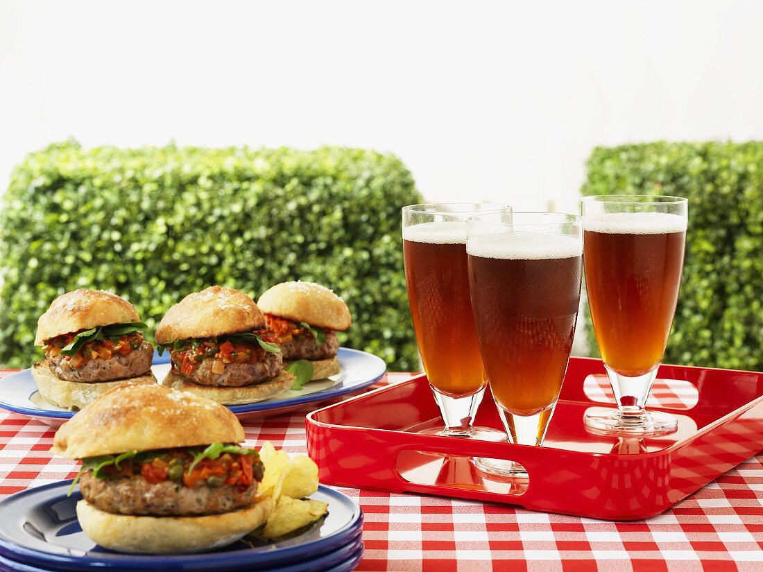 Hamburger und Bier auf einem Picknicktisch