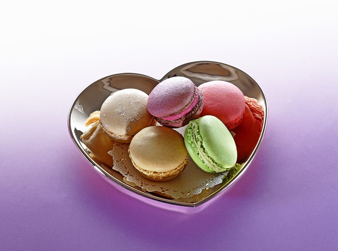 Different types of macaroons in a heart-shaped dish