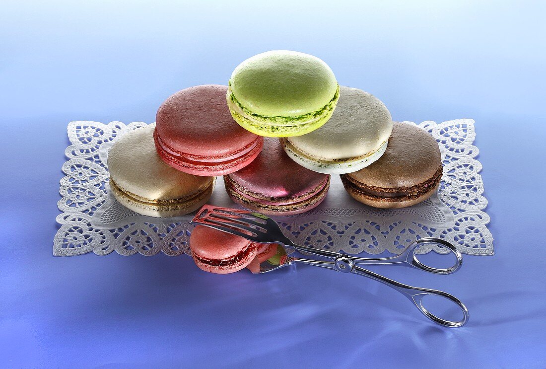 Different types of macaroons, stacked, on a cake paper placemat
