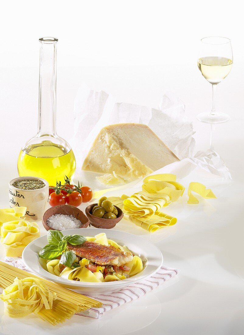 Stillleben mit Nudeln, Olivenöl, Parmesan, Gewürzen, Gemüse und Weißwein