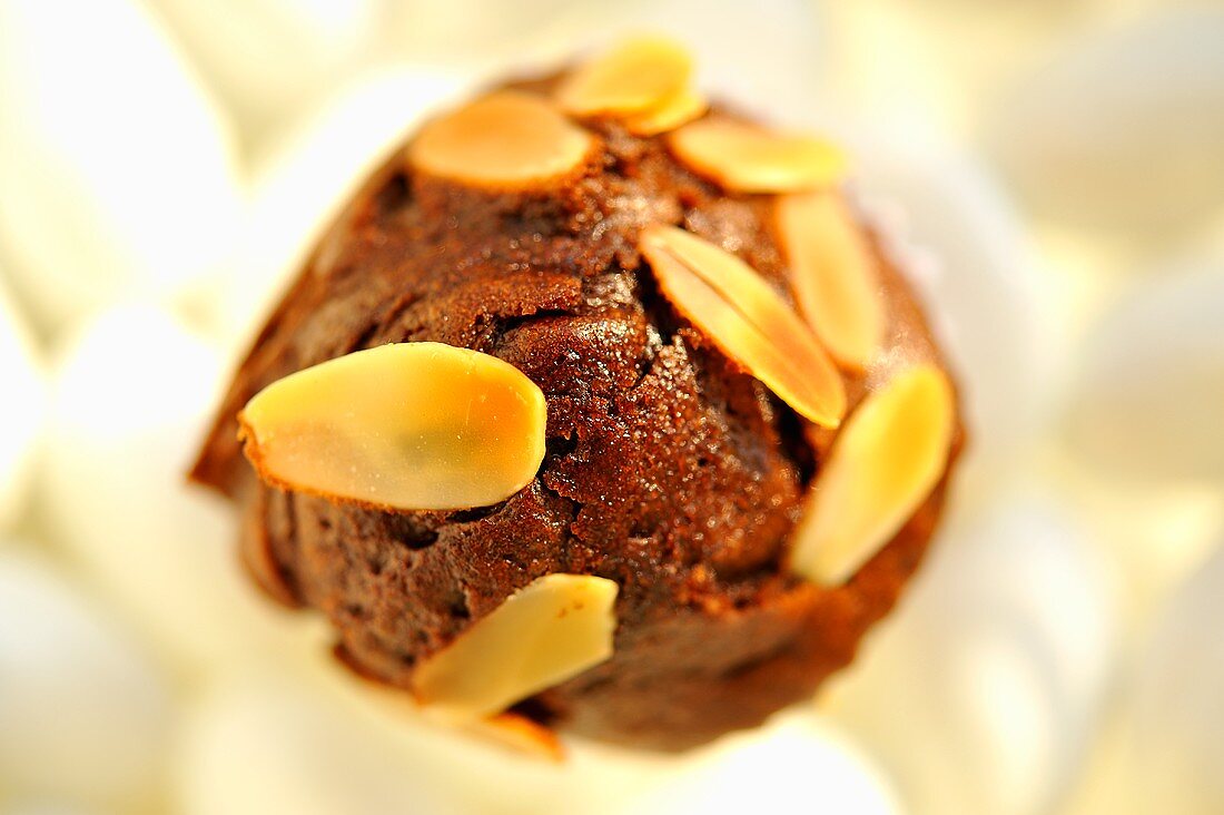 A brownie muffin with slivered almonds