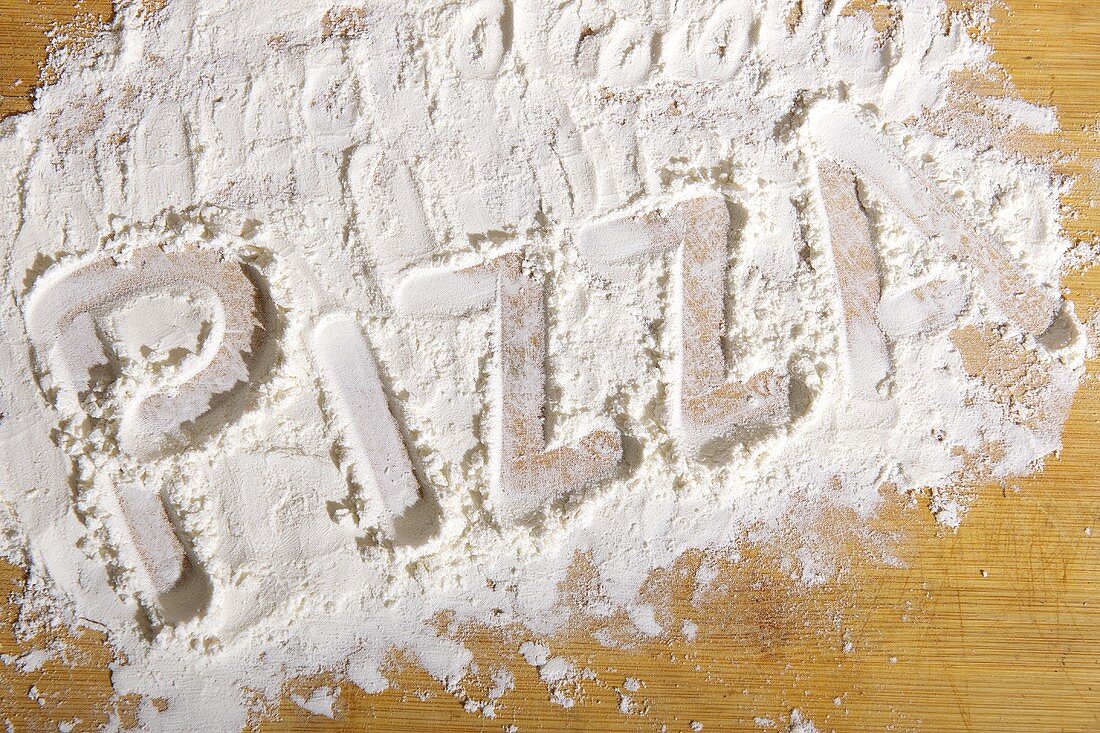 The word 'pizza' written in flour