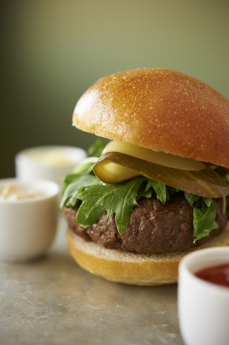 Hamburger with Arugula and Sliced Dill Pickles; Assorted Condiments