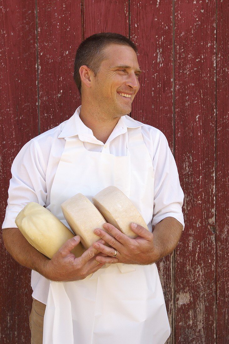 Cheese Maker in Apron Holding Goat Cheese Rounds