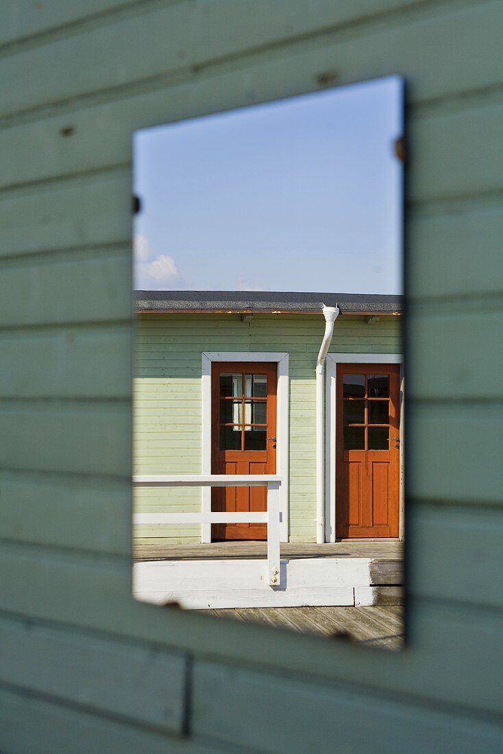 Reflection of a wooden house in a mirror