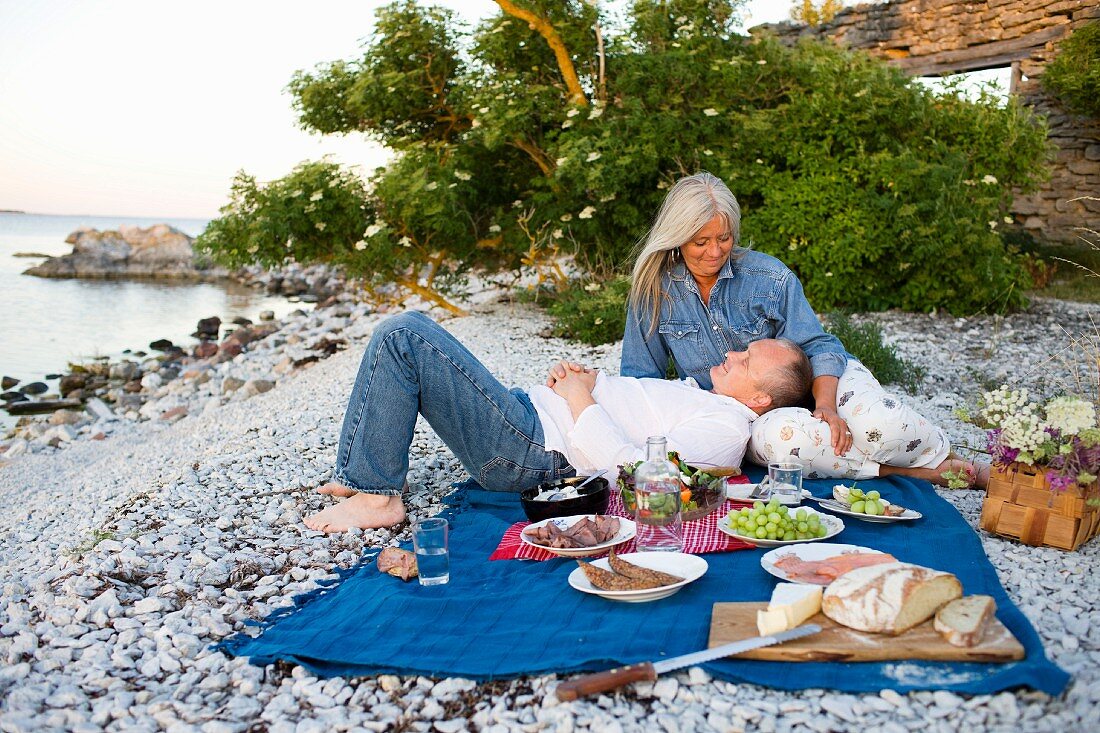An old couple having a picnic on the beach