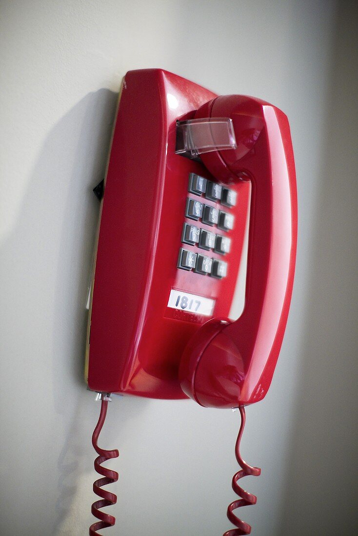 Ein rotes Tastentelefon an der Wand hängend