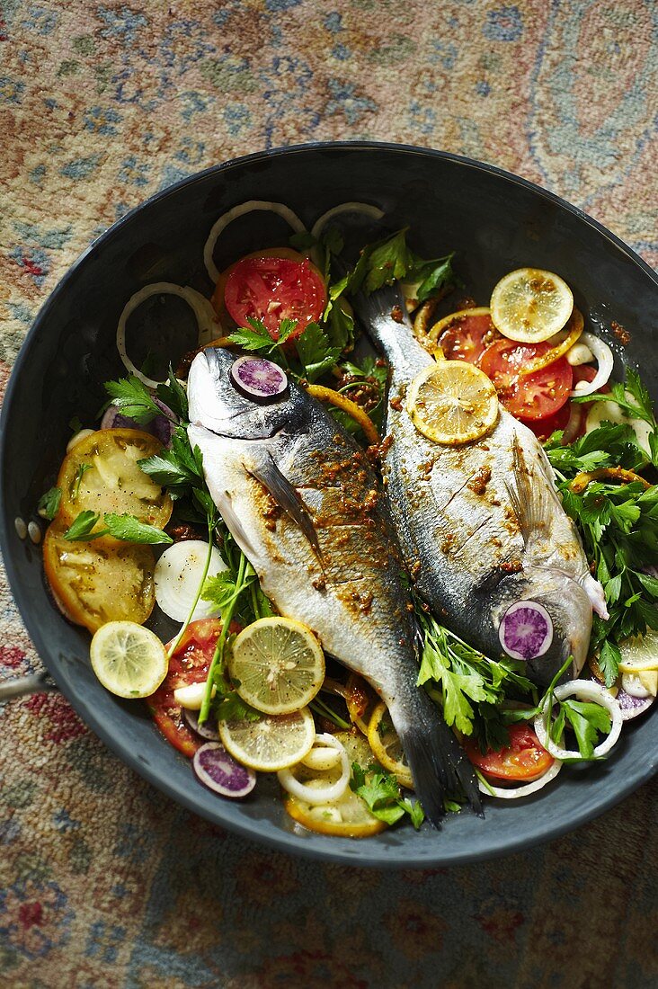 Dorade Fish Cooked in a Skillet with Tomatoes, Lemons and Parsley