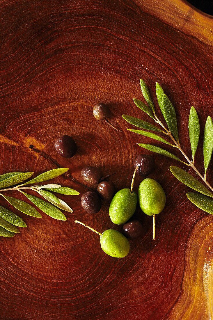 Frische Oliven auf Holzscheibe