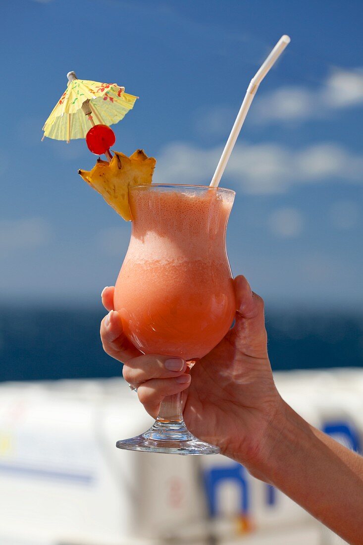 A woman holding a fruit cocktail